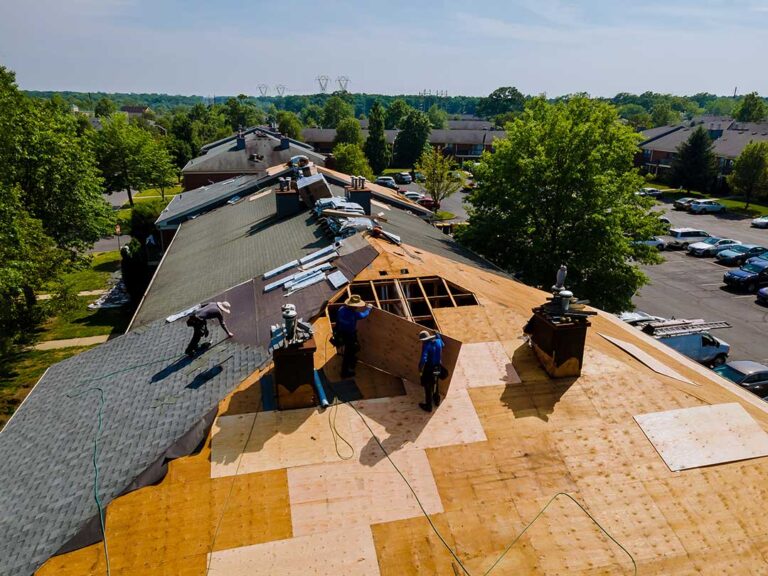 Rain falling on a roof above an insulated attic with gutters and downspouts visible.